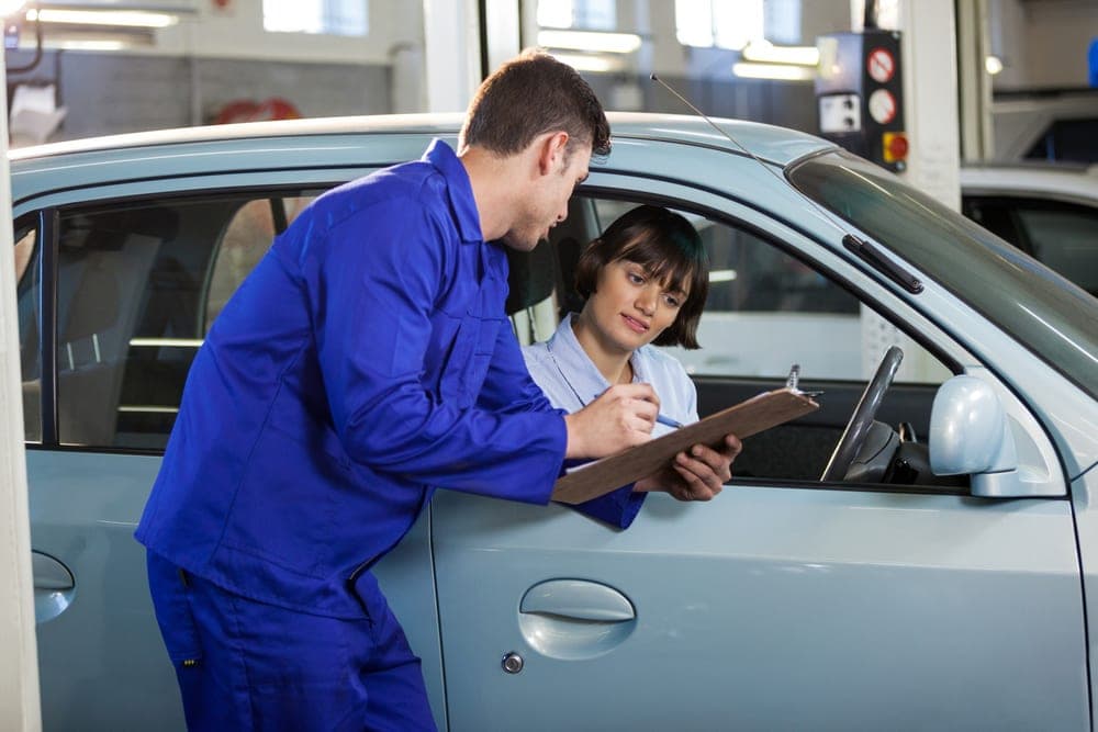 A mechanic showing an inspection quotation to a customer